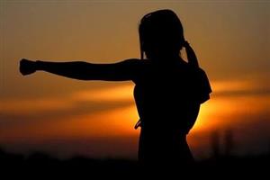 Silhouette of woman practicing karate at sunset